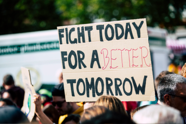 Protester's cardboard sign reading 'Fight today for a better tomorrow'.