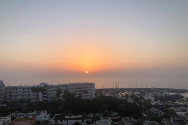 Balcony view of the sea and hotels with sunset in Tenerife