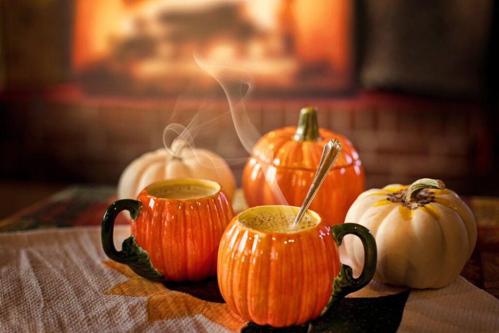 An image showing pumpkin shaped mugs with hot drinks in them