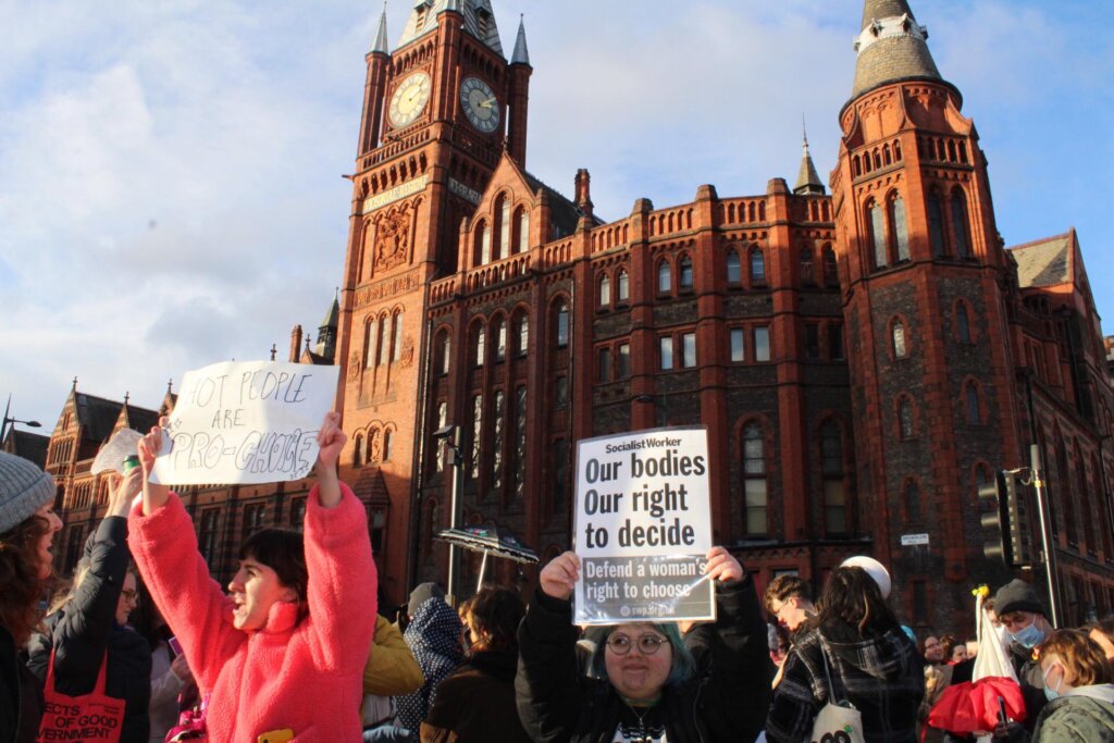 Pro-choice protest for abortion rights at the University of Liverpool. One sign reads "Hot people are pro-choice" and another reads "Our bodies Our right to decide Defend a woman's right to choose"